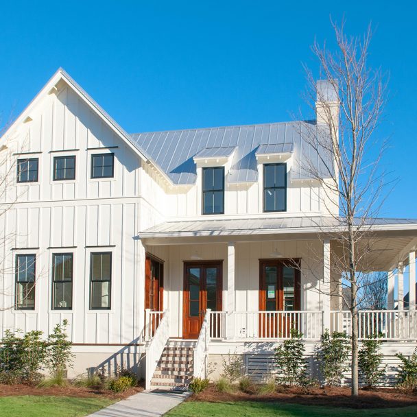A white sided home with stained front doors