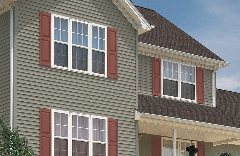 Green vinyl siding with burnt red shutters